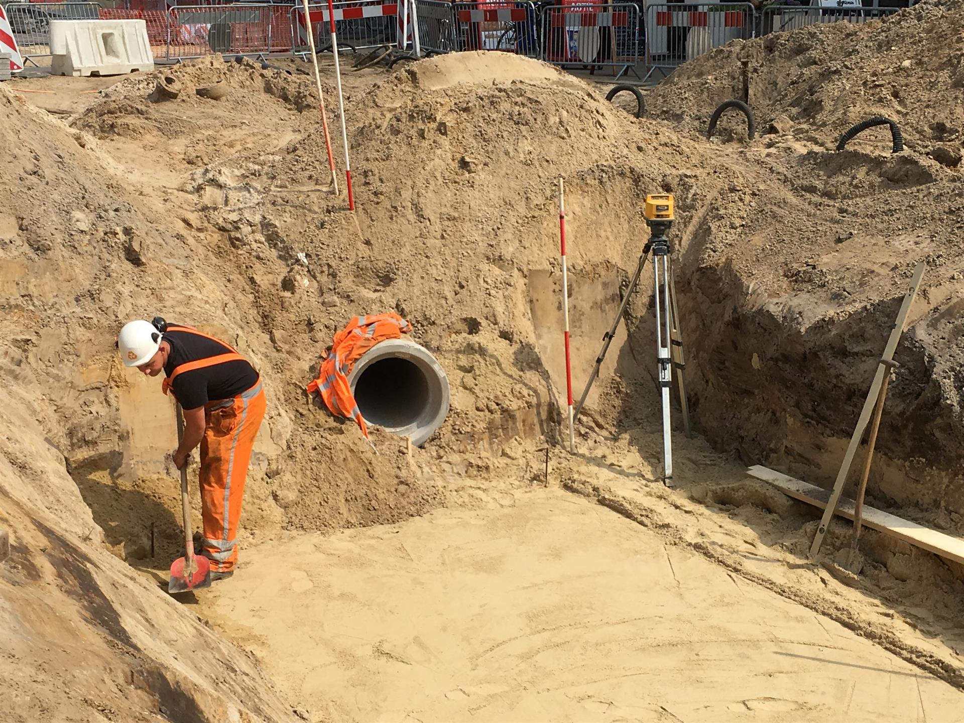 De bodem wordt uitgegraven en vlak gemaakt voor de aanleg van de betonnen beekelementen.